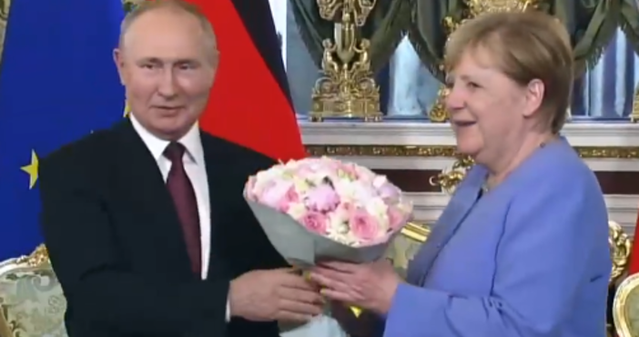 Кадър ТАССВладимир Путин подари букет на Анхела Меркел Германският канцлер Ангела