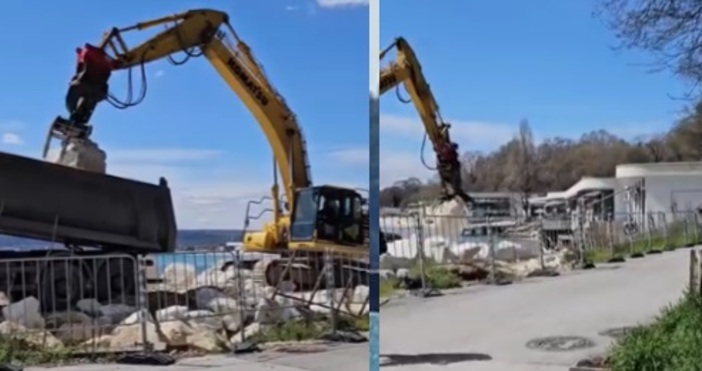 Багер наслагва огромни каменни блокове за да отвоюва земя от